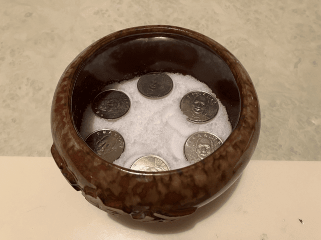 3、接著將硬幣圍著陶器內部,以圓形的方式平均的擺放在鹽的上方。 (※人像統一朝上,或是數字統一朝上都可以)